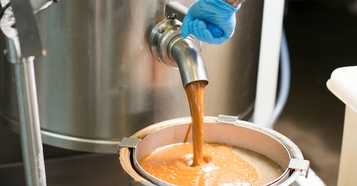 hot fudge mix pouring out of a machine tap