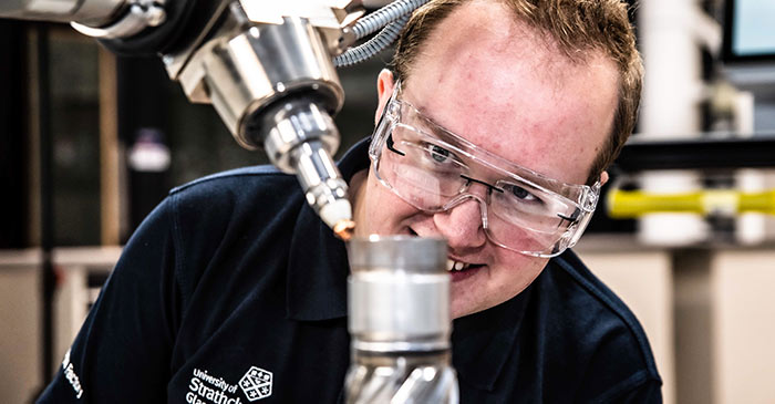 Man looking into a piece of machinery at NMIS